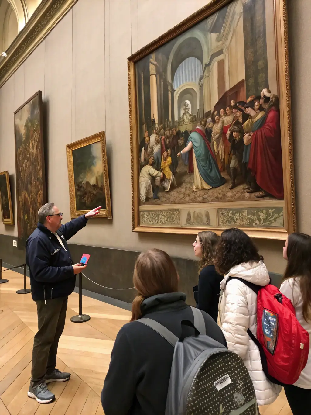 A high-quality image showcasing a guided tour of a local art museum organized by ARTINVEST, with participants listening attentively to the guide.